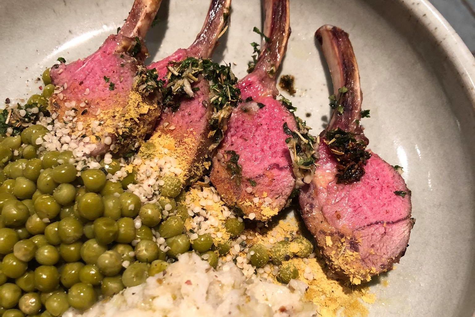 Lamb rack served with peas and mashed potato